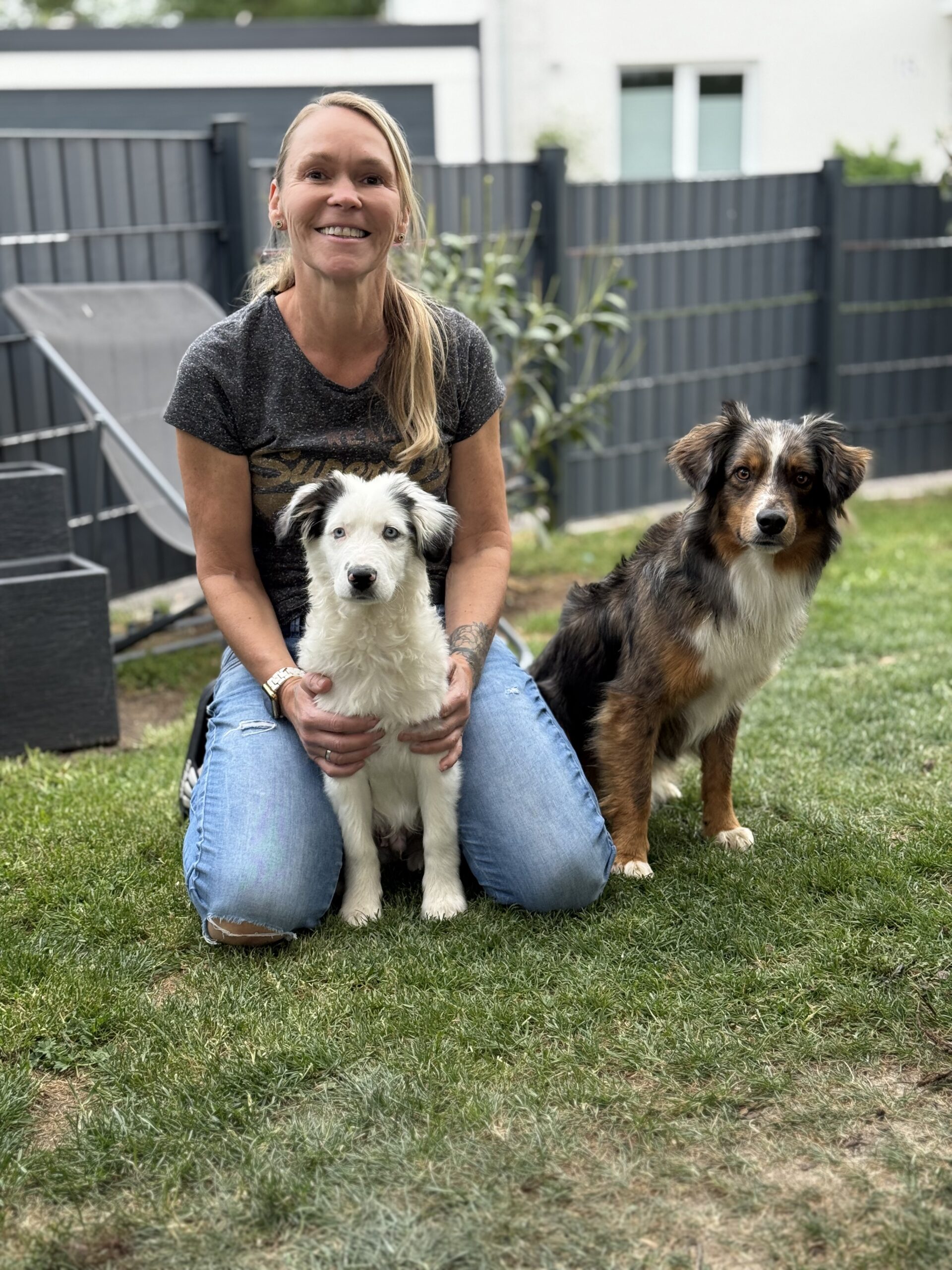 Silke mit den Miniature Australian Shepherds Luis und Nemo im Garten